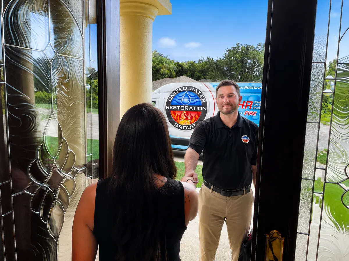 A United Water Restoration technician welcomed calmly at a customer's front door